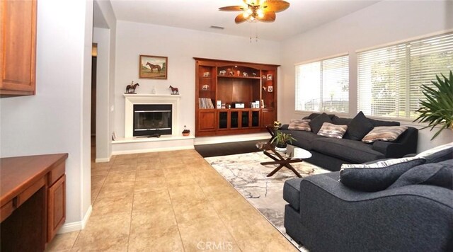23801 Hollingsworth Dr, Murrieta, CA 92562 - living room featuring a ceiling fan, visible vents, light tile patterned floors, baseboards, and a glass covered fireplace