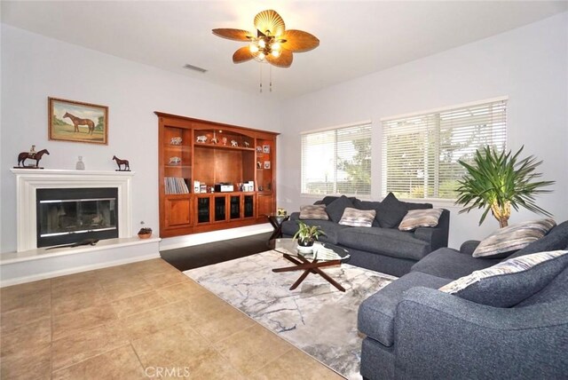 23801 Hollingsworth Dr, Murrieta, CA 92562 - living room with a glass covered fireplace, tile patterned flooring, ceiling fan, and visible vents