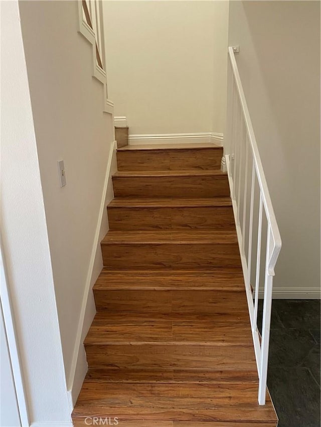 stairs featuring baseboards and wood finished floors
