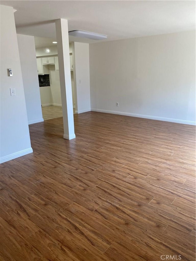interior space featuring baseboards and dark wood-style flooring