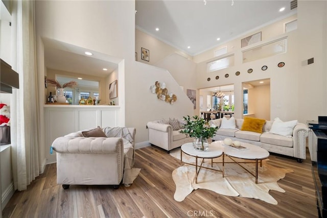 15 Pebble Bch, Coto De Caza, CA 92679 - living area featuring crown molding, a towering ceiling, baseboards, wood finished floors, and a chandelier