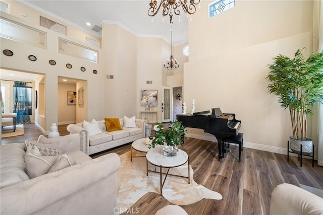 living area featuring wood finished floors, an inviting chandelier, ornamental molding, and plenty of natural light