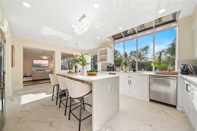 15 Pebble Bch, Coto De Caza, CA 92679 - kitchen featuring stainless steel dishwasher, a sink, a breakfast bar, a center island, and white cabinets