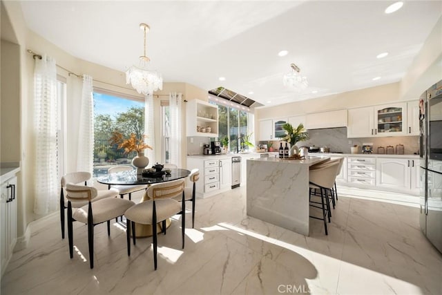 dining area featuring recessed lighting, marble finish floor, and a chandelier