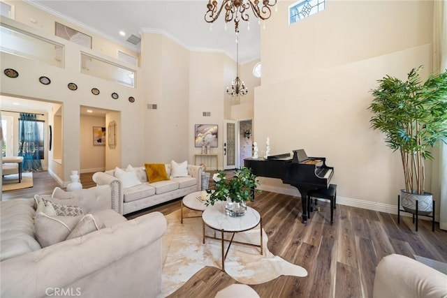 living area featuring crown molding, a notable chandelier, a wealth of natural light, and wood finished floors