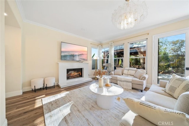 15 Pebble Bch, Coto De Caza, CA 92679 - living room with wood finished floors, a lit fireplace, a chandelier, baseboards, and crown molding
