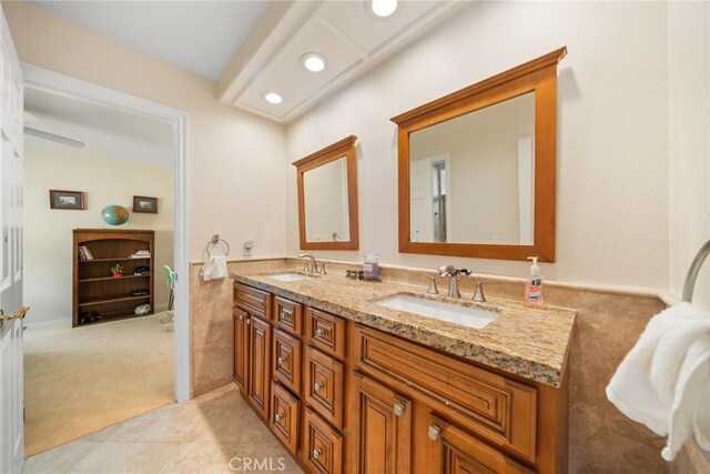 bathroom with tile patterned flooring, recessed lighting, double vanity, and a sink
