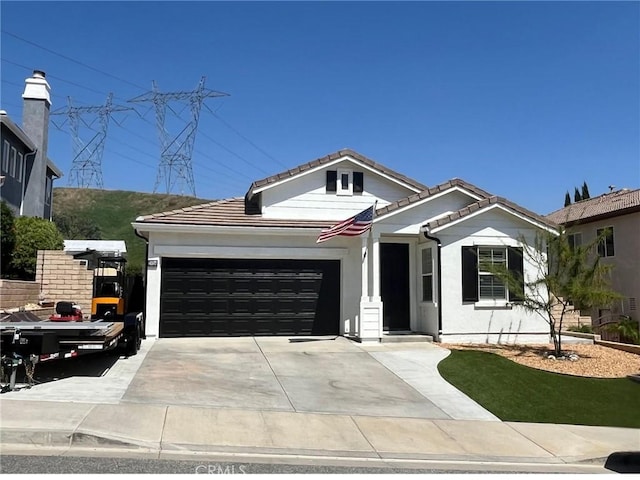 single story home featuring concrete driveway, an attached garage, and a tile roof