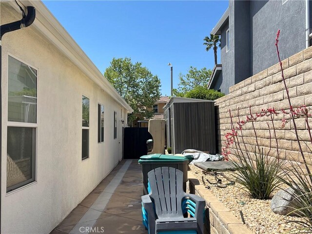 view of side of property featuring fence and stucco siding