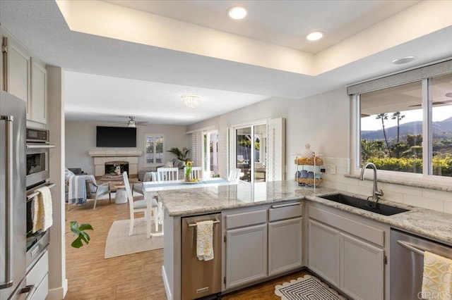 962 Chardonney Way, Escondido, CA 92029 - kitchen with stainless steel dishwasher, a sink, a peninsula, a fireplace, and open floor plan