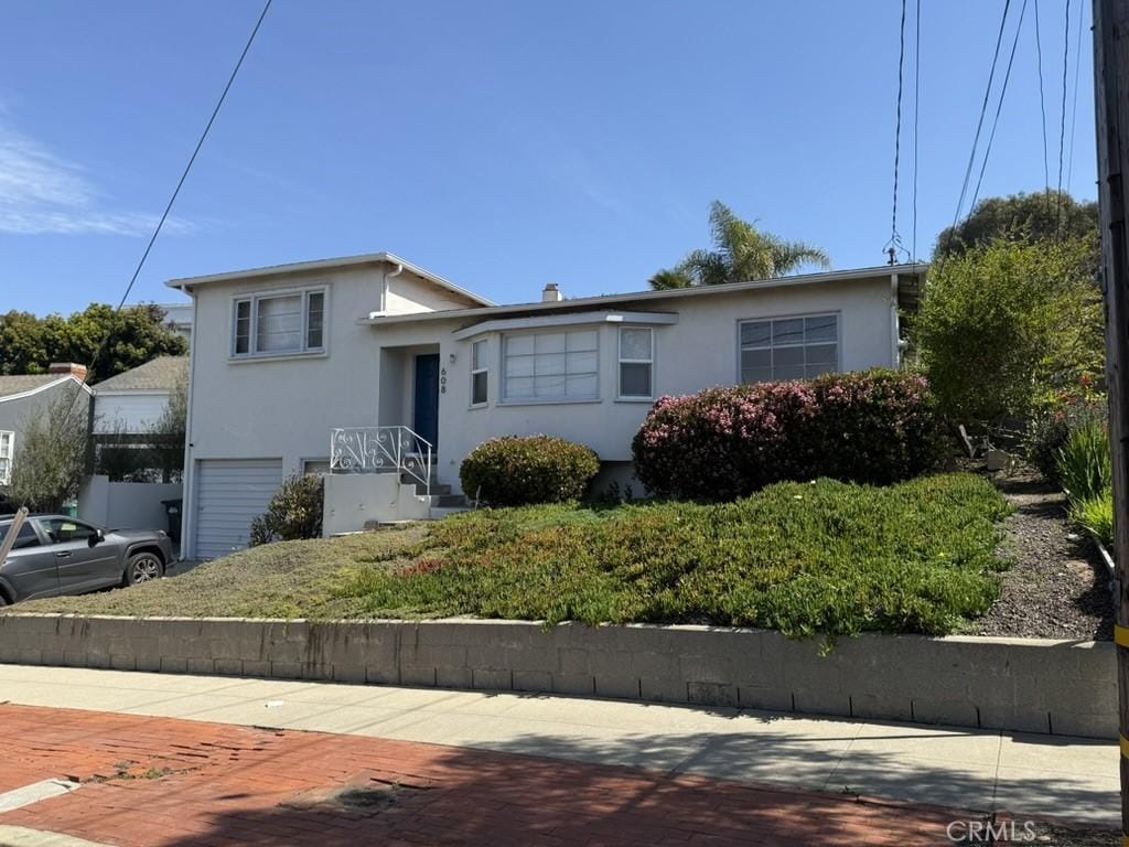 tri-level home with stucco siding and a garage