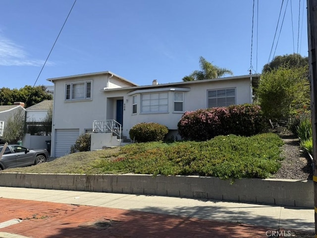 tri-level home with stucco siding and a garage