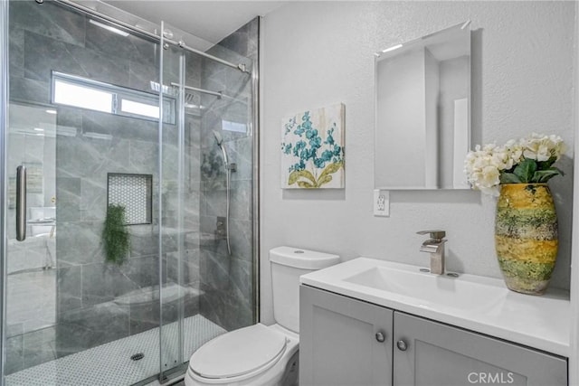 full bathroom featuring toilet, vanity, and a stall shower
