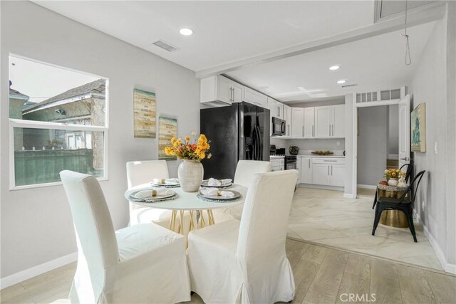 dining room featuring baseboards, light wood-style flooring, visible vents, and recessed lighting