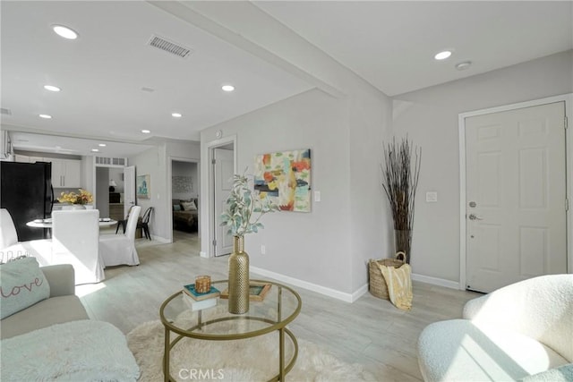 living room with baseboards, light wood-style flooring, visible vents, and recessed lighting