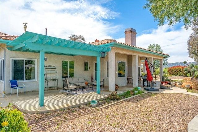 back of house with outdoor lounge area, a patio area, and stucco siding