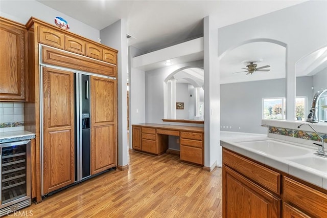 full bathroom featuring tasteful backsplash, a ceiling fan, wood finished floors, vanity, and beverage cooler