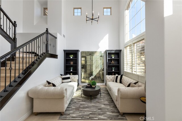29311 Paseo Palmar, San Juan Capistrano, CA 92675 - living area featuring a towering ceiling, a chandelier, stairway, baseboards, and wood finished floors