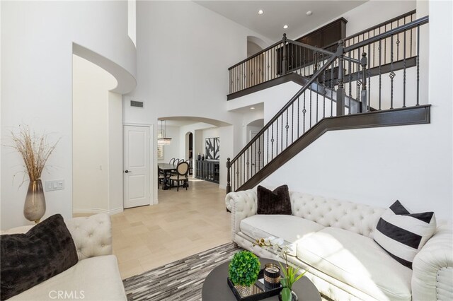29311 Paseo Palmar, San Juan Capistrano, CA 92675 - living area featuring arched walkways, stairs, a towering ceiling, baseboards, and recessed lighting