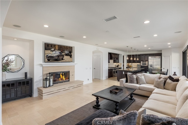 29311 Paseo Palmar, San Juan Capistrano, CA 92675 - living area featuring arched walkways, a glass covered fireplace, and recessed lighting