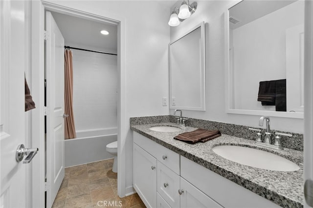 bathroom with visible vents, a sink, double vanity, and toilet