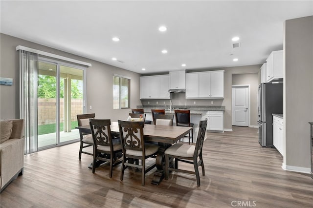 dining room featuring visible vents, baseboards, wood finished floors, and recessed lighting