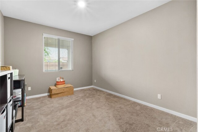 interior space with baseboards and light carpet
