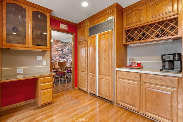 130 N Avenida Veracruz, Anaheim, CA 92808 - kitchen featuring paneled refrigerator, light wood-type flooring, built in study area, light countertops, and glass insert cabinets