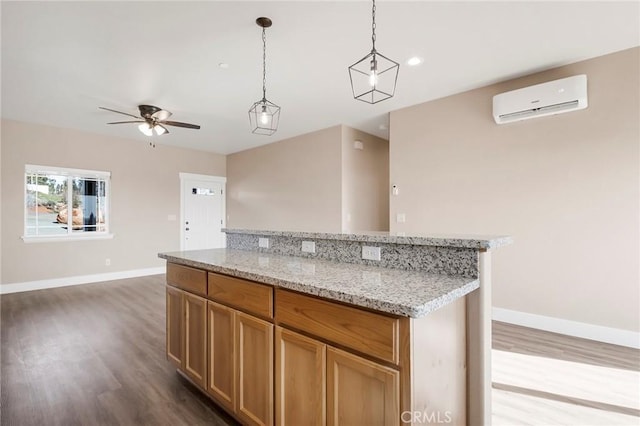 1411 Elliott Rd, Paradise, CA 95969 - kitchen featuring a wall mounted AC, dark wood-style floors, ceiling fan, hanging light fixtures, and a center island