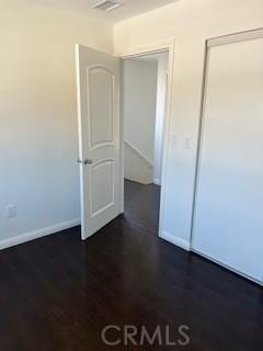 586 W 1st St, San Pedro, CA 90731 - unfurnished bedroom with dark wood-style floors, visible vents, and baseboards