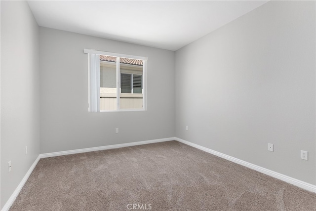 empty room with baseboards and carpet flooring