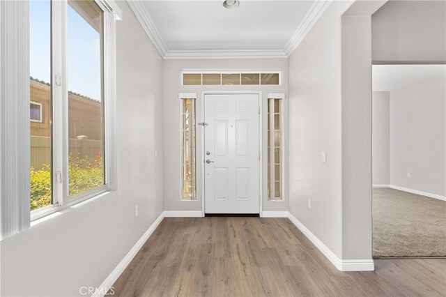 foyer entrance with baseboards, ornamental molding, and wood finished floors