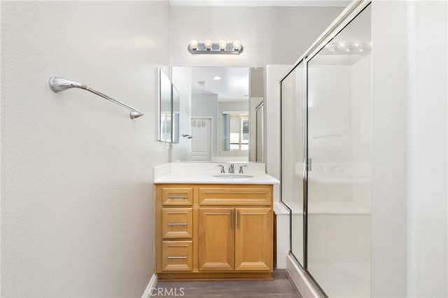 full bathroom with vanity, wood finished floors, and a stall shower
