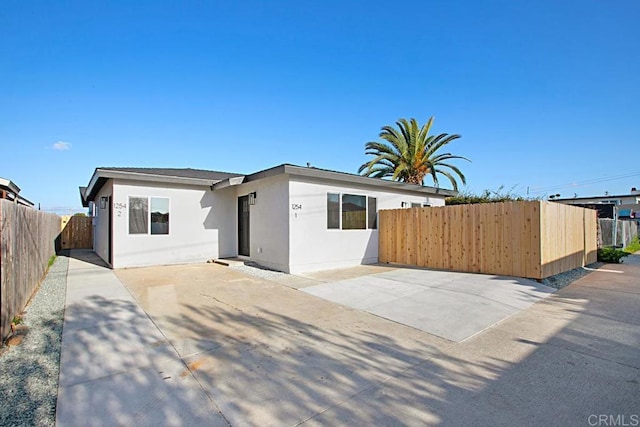view of front of home with stucco siding and fence