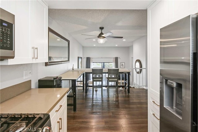 27633 Nugget Dr Unit 1, Canyon Country, CA 91387 - kitchen featuring a textured ceiling, dark wood-style flooring, white cabinetry, ceiling fan, and appliances with stainless steel finishes