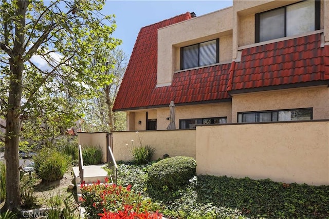 27633 Nugget Dr Unit 1, Canyon Country, CA 91387 - view of side of property featuring a tile roof, stucco siding, and fence