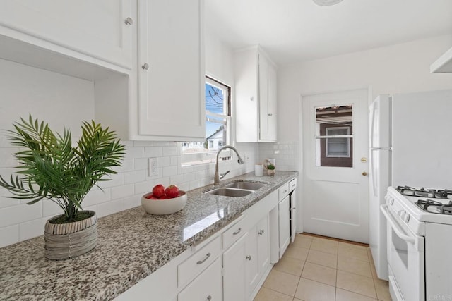 kitchen featuring white cabinetry, a sink, white gas range, light tile patterned flooring, and backsplash