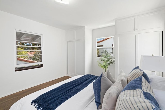 bedroom featuring dark wood-style flooring and baseboards