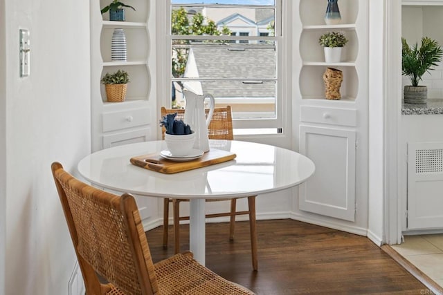 dining space featuring radiator heating unit and wood finished floors