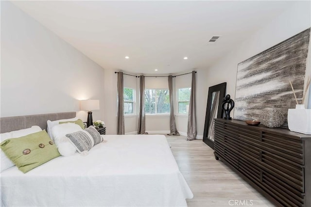 bedroom featuring baseboards, light wood-style flooring, visible vents, and recessed lighting