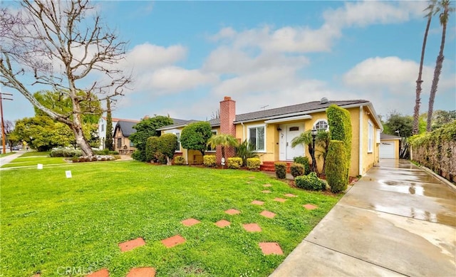 view of front of home featuring a chimney, a front lawn, and stucco siding