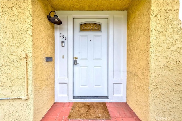 view of exterior entry featuring stucco siding
