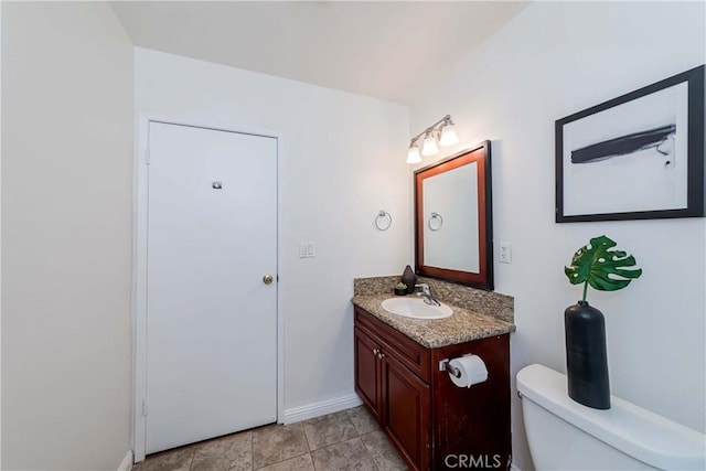bathroom featuring baseboards, vanity, and toilet