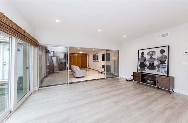 unfurnished living room with recessed lighting, a healthy amount of sunlight, visible vents, and light wood-type flooring