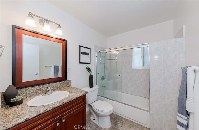 full bath with vanity, tile patterned flooring, bath / shower combo with glass door, and toilet