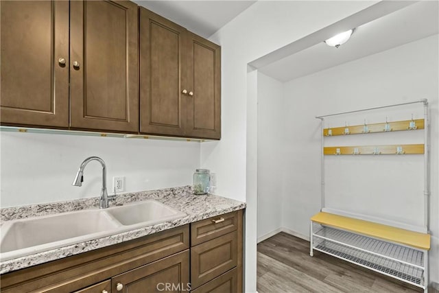 8912 Elizabeth Ave, South Gate, CA 90280 - kitchen with a sink, light wood finished floors, light countertops, dark brown cabinets, and baseboards