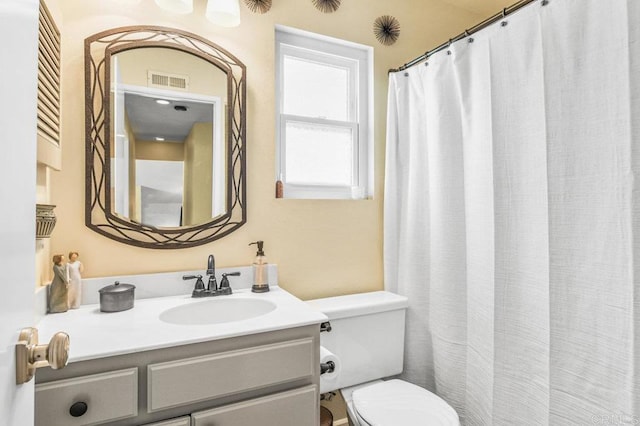 bathroom featuring toilet, visible vents, and vanity