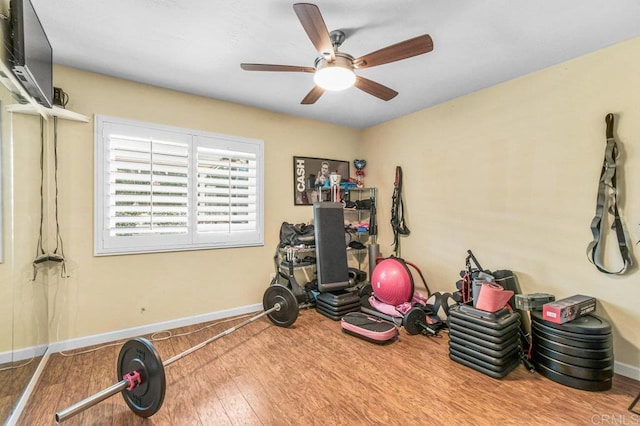 workout area with baseboards, a ceiling fan, and wood finished floors