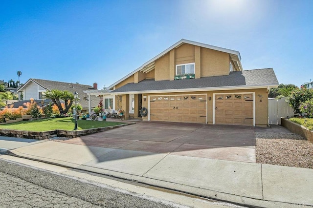 view of front of house featuring a garage, fence, a front lawn, concrete driveway, and stucco siding