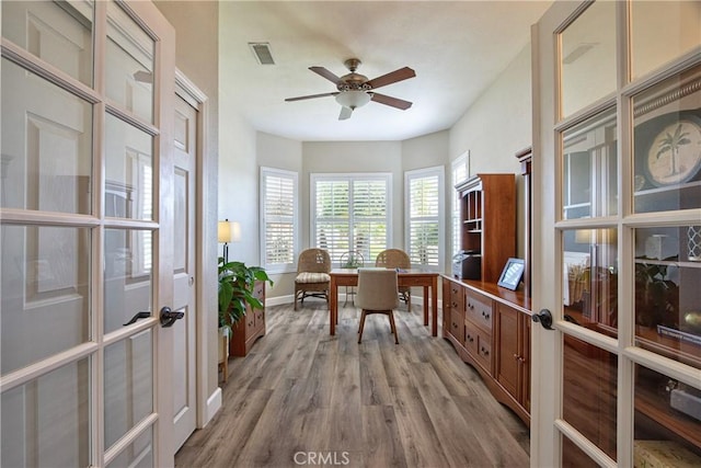 office with visible vents, a ceiling fan, light wood-style floors, and french doors
